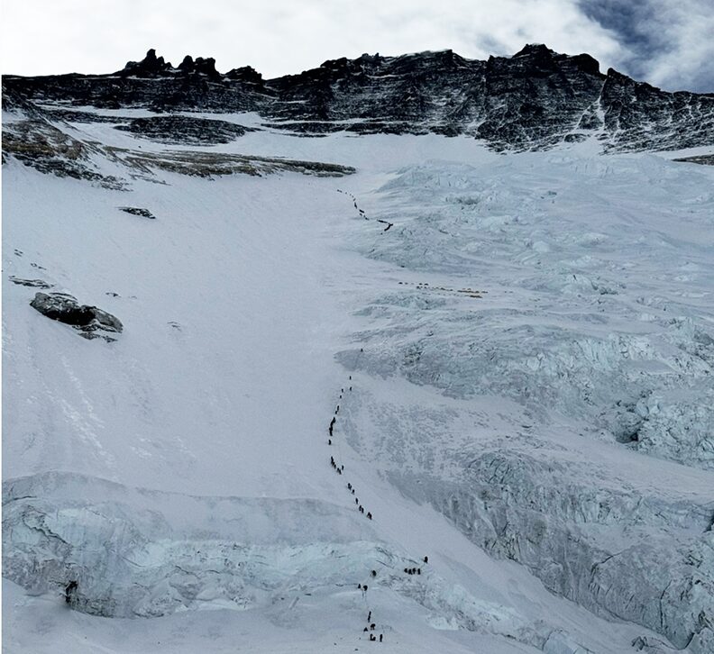 a long line of small climbers, seen from the air